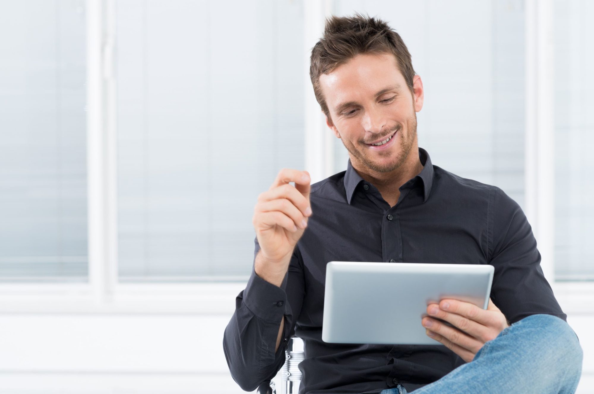 19500115 – portrait of a handsome young happy man using digital tablet